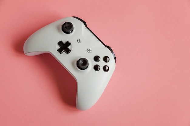 Manette de jeu blanche, console de jeux sur fond rose pastel