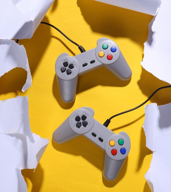 Manette de jeu rétro sur fond jaune avec papier déchiré blanc Tendance ombre Concept art Minimalisme