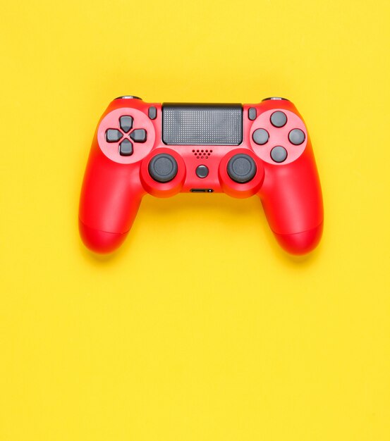 Manette de jeu rouge moderne sur fond jaune.