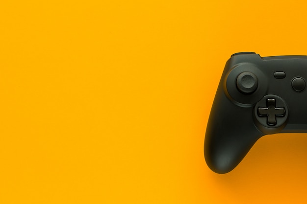 une manette de jeu sur une table jaune et copie espace