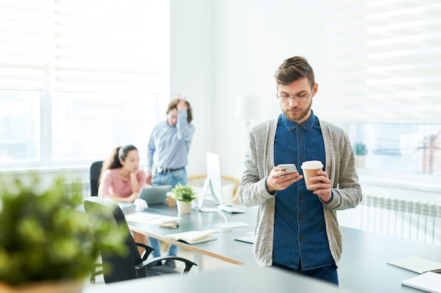 Mangeoire hipster pensif, boire du café dans la salle de réunion