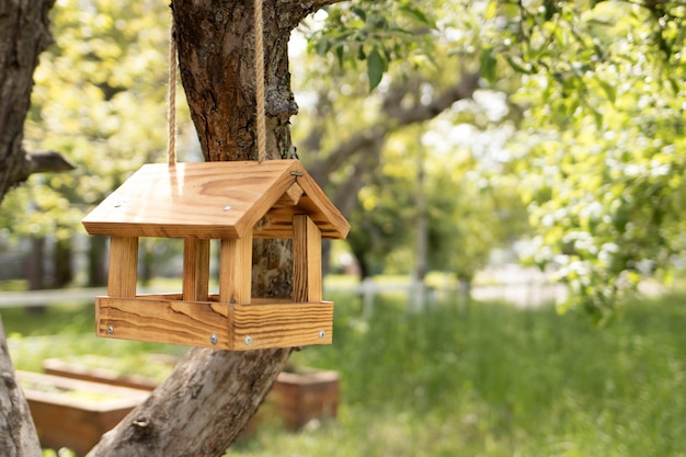 Mangeoire à oiseaux en bois, une maison pour les oiseaux sur un arbre en été