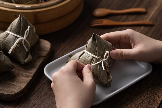 Manger des boulettes de riz Zongzi pour le concept d'événement de célébration traditionnel chinois du festival des bateaux-dragons (festival de Duanwu)