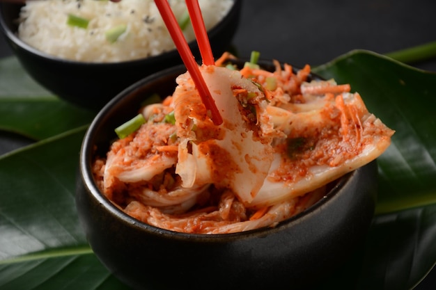 Manger du chou kimchi dans un bol avec des baguettes Cuisine coréenne