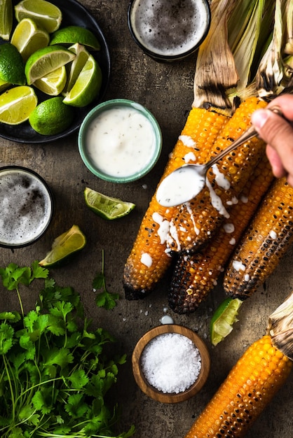 Manger des épis de maïs grillés avec de la bière fraîche aux herbes et de la salsa