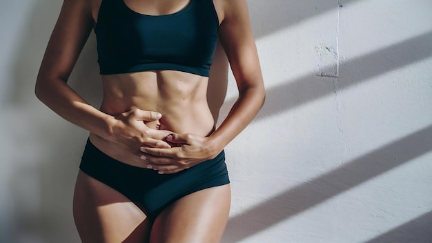 Manger nutrition douleur d'estomac maigre femme bronzée ventre sur le mur blanc