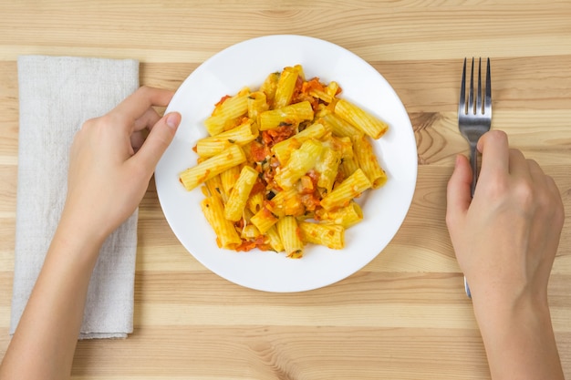 Manger des pâtes avec sauce et fromage