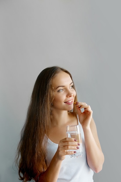 Manger sainement, mode de vie. Gros plan d'une femme souriante heureuse prenant la pilule