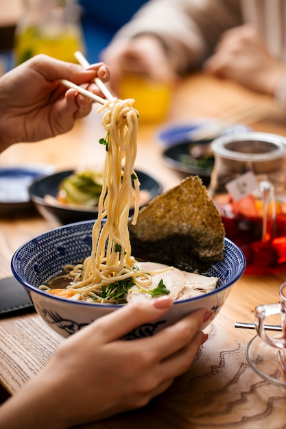 Manger de la soupe de nouilles ramen shio japonais avec des baguettes