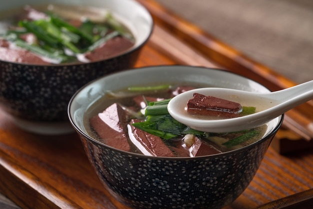 Manger de la soupe de sang de porc traditionnelle taïwanaise avec des feuilles de moutarde marinées