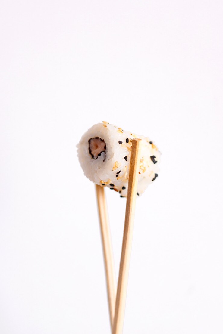 Manger des sushis avec des baguettes. Sushi roll cuisine japonaise au restaurant isolé sur fond blanc.