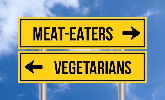 Photo les mangeurs de viande sur le panneau de signalisation des végétariens sur le fond du ciel nuageux