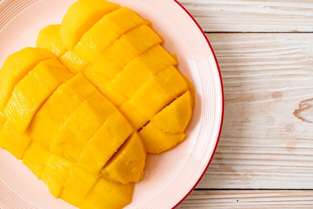 mangue fraîche et dorée tranchée sur assiette