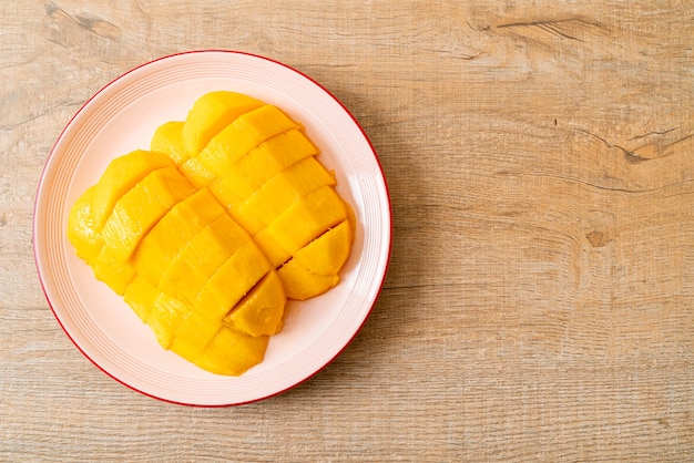 mangue fraîche et dorée tranchée sur assiette