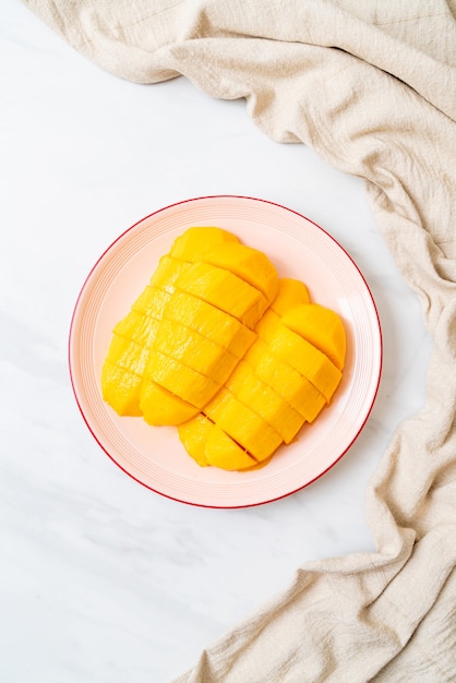 mangue fraîche et dorée tranchée sur assiette