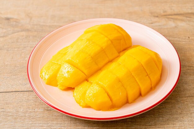 mangue fraîche et dorée tranchée sur assiette