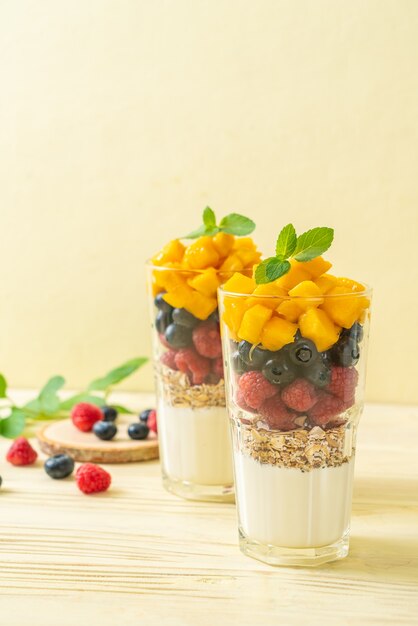 mangue, framboise et myrtille maison avec yaourt et granola - style alimentaire sain