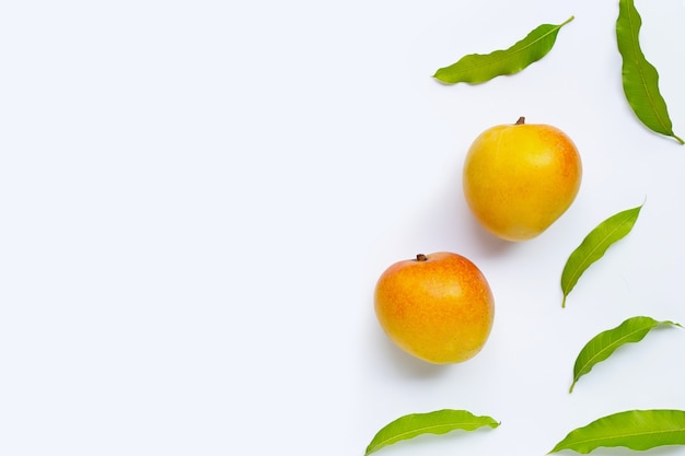 Mangue, fruits tropicaux avec des feuilles sur fond blanc. Vue de dessus