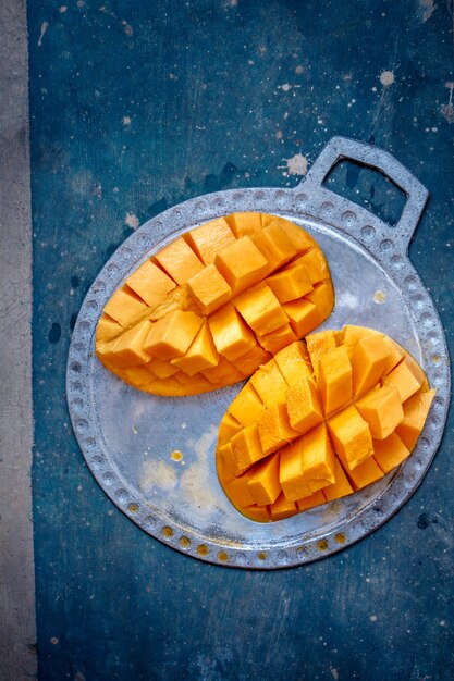 Mangue juteuse et mûre sur une plaque de métal coupée en cubes