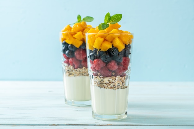 mangue maison, framboise et myrtille avec yogourt et granola - style alimentaire sain