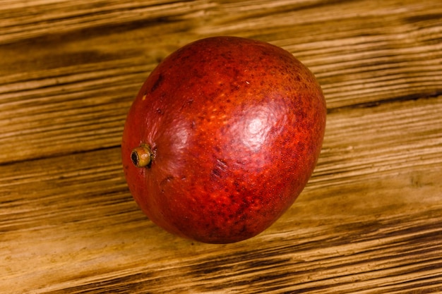 Mangue rouge entière sur une table en bois