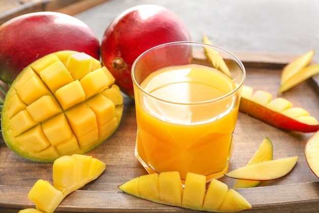 Photo mangue savoureuse et verre de jus sur table