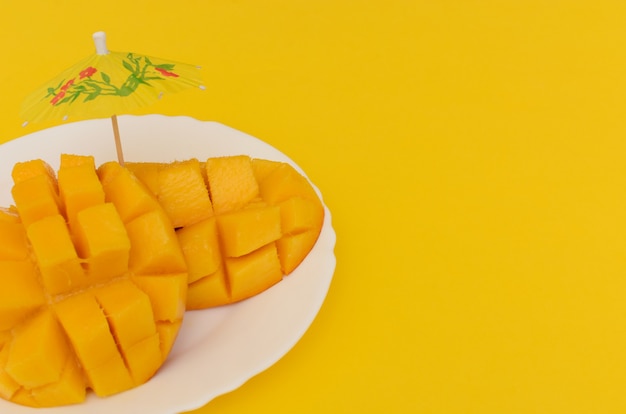 Mangue tranchée servie dans une assiette blanche sur fond coloré