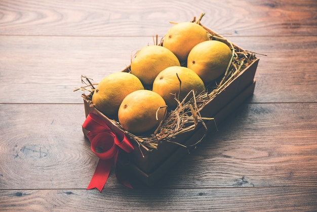 Mangues Alphonso Dans Une Boîte-cadeau Sur Herbe Et Attachées Avec Un Ruban Rouge, Mise Au Point Sélective