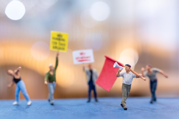 Des manifestants en miniature tenant des pancartes levant les mains pour la révolution