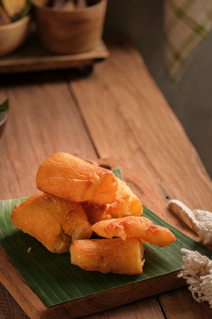 Le manioc frit est servi sur une planche à découper avec une base de feuille de bananier. Disposé de telle manière avec un thème de table de cuisine classique