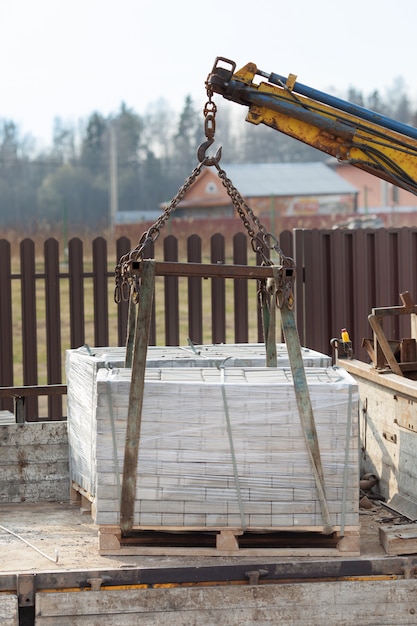 Manipulateur avec dalles dans la construction de la chaussée.