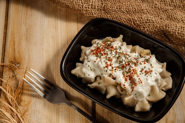 Manlama turc sur une assiette avec poivron rouge, sauce aux tomates, yogourt et menthe