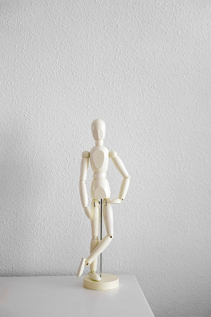 Mannequin en bois blanc se dresse sur la table blanche. Proportion du corps humain