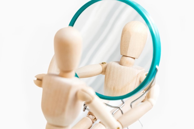 Mannequin en bois regarde son reflet dans le miroir