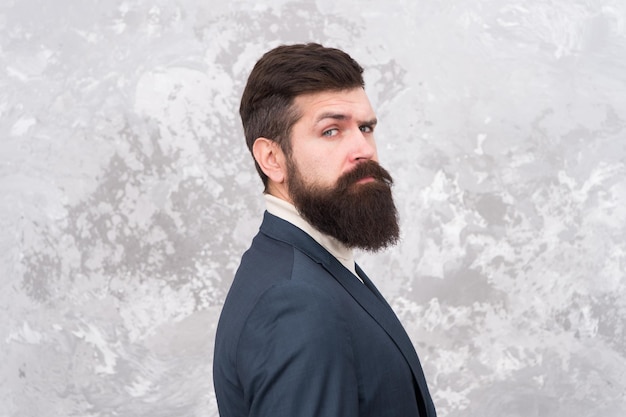 Mannequin brutal avec une longue barbe et une moustache. Style de mode des gens d'affaires. Poils et soins du visage. Bel homme d'affaires barbu porte un costume formel. Concept de vêtements pour hommes et de mode.