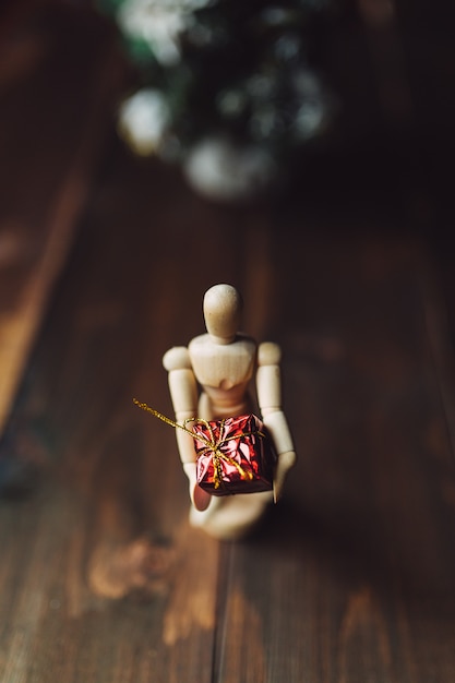 Mannequin à charnière en bois avec le cadeau et l'arbre de Noël