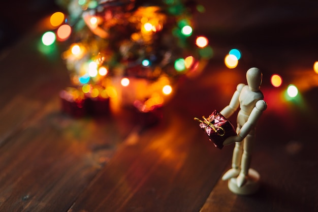 Mannequin à charnière en bois avec le cadeau et l'arbre de Noël