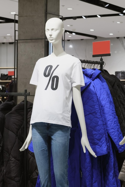 Mannequin femme en plastique blanc dans un t-shirt blanc avec un symbole de pourcentage et un jean