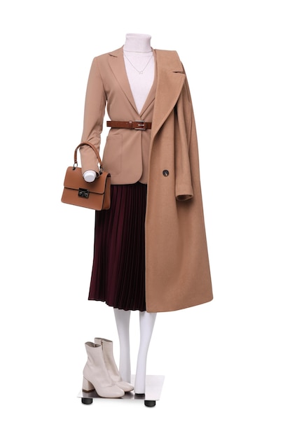 Mannequin femme vêtue d'une jupe à col roulé et d'un trench-coat avec des accessoires isolés sur une tenue élégante blanche