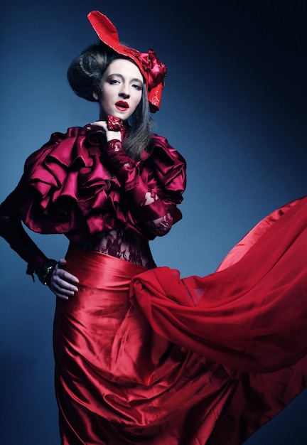Mannequin glamour en costume d'élégance rouge avec chapeau rouge