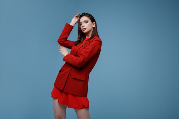 Mannequin en jupe veste de costume rouge Belle jeune femme Studio shot Fond bleu