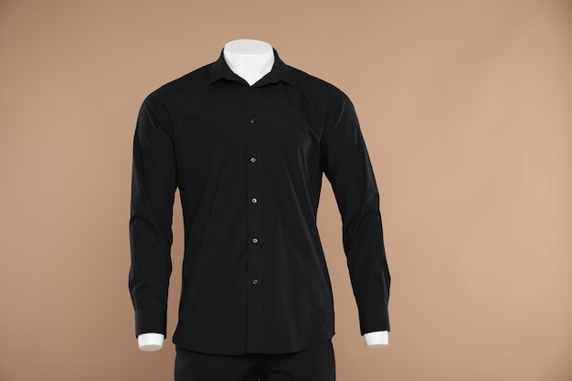 Mannequin masculin avec une tenue élégante sur un fond brun clair