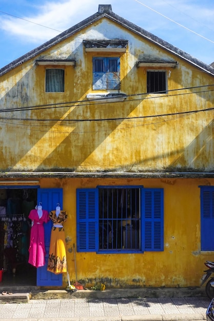 Photo des mannequins sans tête près d'un mur jaune contre le ciel bleu à hoi an, une vieille ville du vietnam.