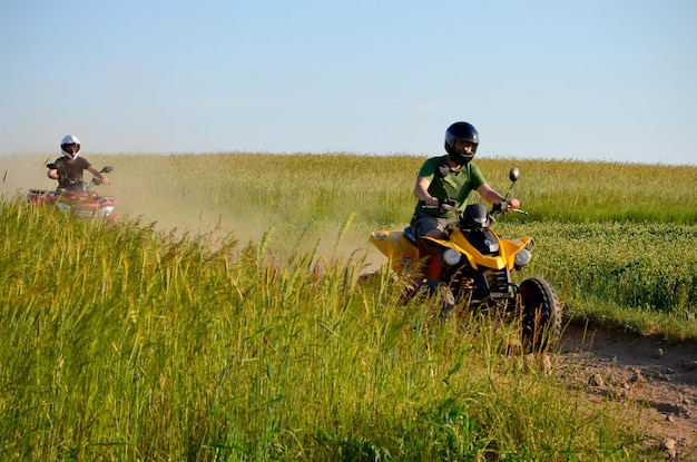 Mans faire du quad sur des activités de plein air sur un chemin de terre dans le flou de mouvement