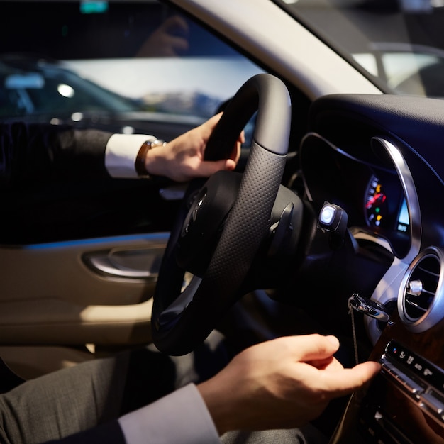 Mans grandes mains sur un volant tout en conduisant une voiture