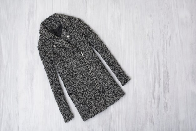 Manteau en laine gris sur fond en bois. Concept à la mode