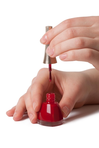 Photo manucure appliquant du vernis à ongles rouge sur les doigts féminins