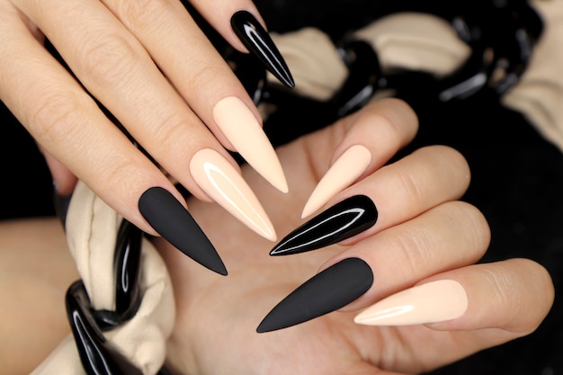 Manucure beige et noire sur une forme d'ongle long