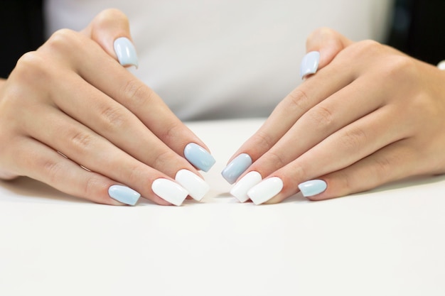 Manucure Bicolore Avec Vernis à Ongles Bleu Et Blanc Sur Fond Blanc