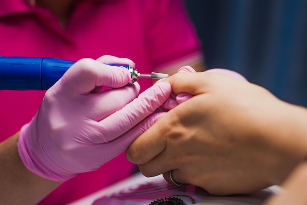 La manucure couvre ses ongles avec du vernis à ongles Une femme fait une manucure et applique du vernis à ongles